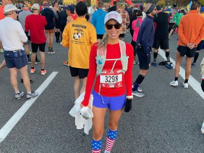Jenn Pellegrino is wearing a blue short, US flag socks and a red top.